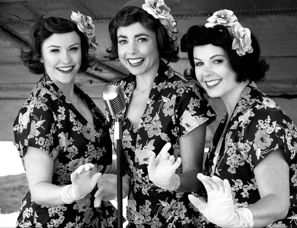 The Pacific Belles wearing matching dresses and a head bow in black and white